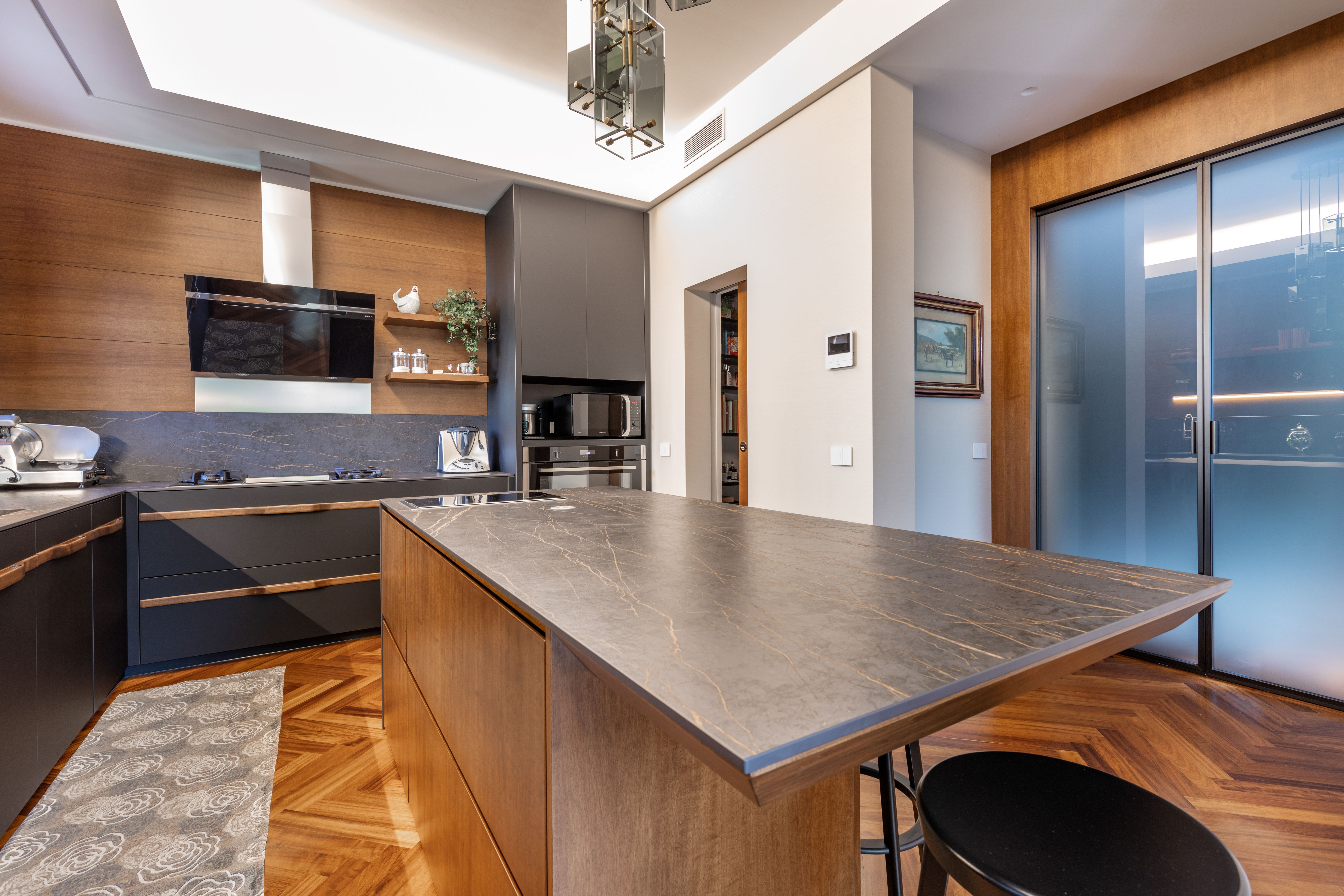 Cucina in fenix e legno con maniglie continue in legno